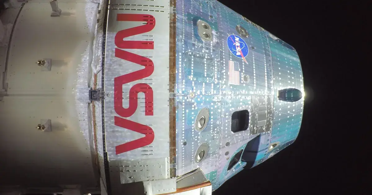 Η κάψουλα Orion της NASA με το λογότυπο NASA, φωτογραφημένη στο διάστημα από κάμερα στα ηλιακά πάνελ της ευρωπαϊκής υπηρεσιακής μονάδας της ESA κατά την Artemis II